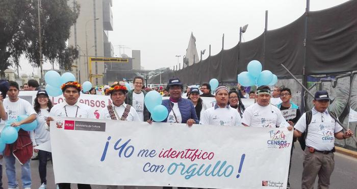 Imagen del pasacalle en la que personal de la DAF sostiene, junto a líderes indígenas, una pancarta que dice "Yo me identifico con orgullo".